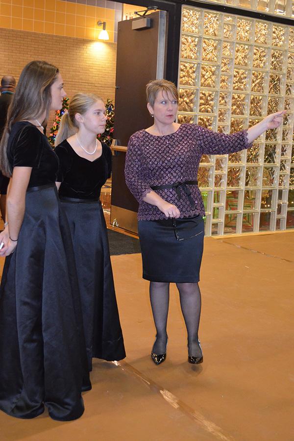 Music instructor Elizabeth Mulkey instructs seniors Anna Hamilton and Mary Sizemore on their entrance path.