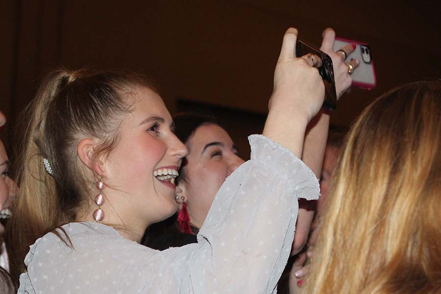 Senior Kyleigh Smith records the senior fathers' performance during the annual Father Daughter dance Feb. 9. Senior fathers performed a rendition of “My Girl” by The Temptations and “We Are The Champions” by Queen.