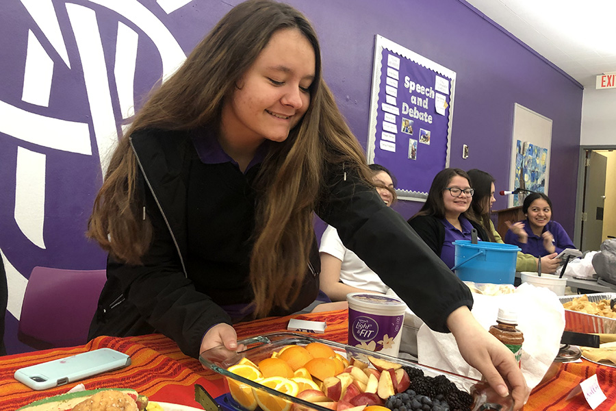 Junior Olivia Valles sets out a fruit tray that she made from home at the LatinX club breakfast March 9.