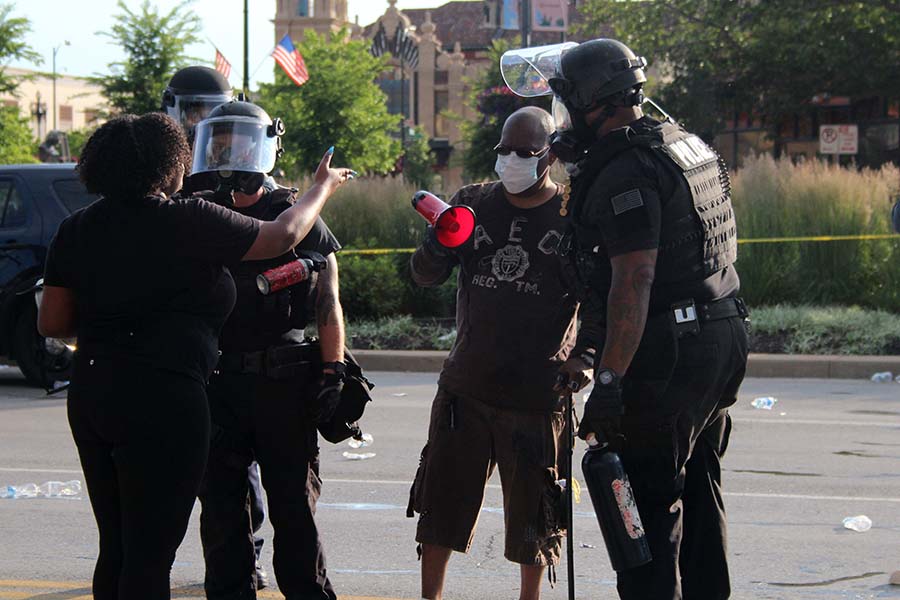 Two protestors argue with two Kansas City Police officers overseeing the Black Lives Matter protest at the Country Club Plaza on May 30. There was a heavy police presence accompanying the protests throughout the weekend. 