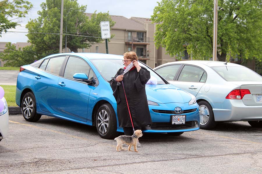 Theology teacher Bonnie Haghirian watches the graduation parade with her dog Tucker in the parking lot on May 21. Teachers gathered in the parking lot celebrate the Class of 2020 and to wish the seniors farewell.