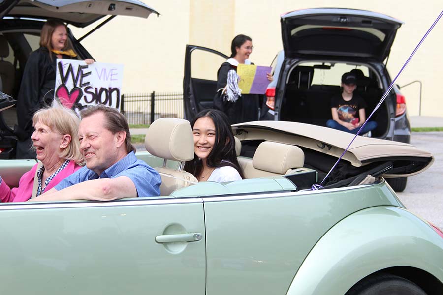 Senior Caroline Ehren drives through the graduation parade while being celebrated by her teachers in the parking lot on May 21.