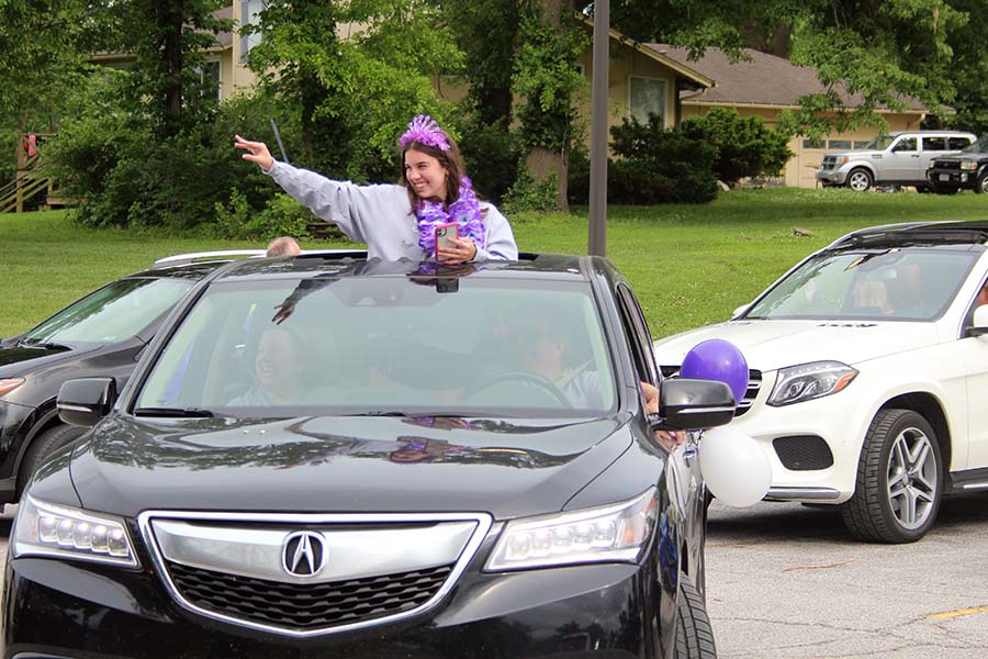 Senior Sophia Angrisano waves and greets her teachers from her car during the graduation parade in the parking lot on May 21.