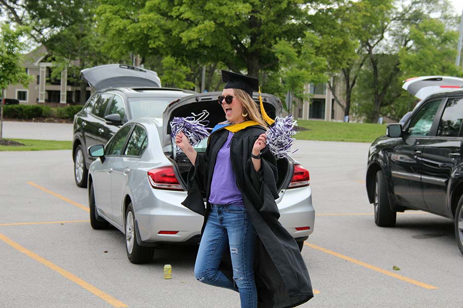 Social Studies Department Chair Jenny Brown-Howerton celebrates while wearing her graduation cap and gown during the graduation parade in the parking lot on May 21. Teachers and faculty wore graduation gowns in support of the seniors during the parade.