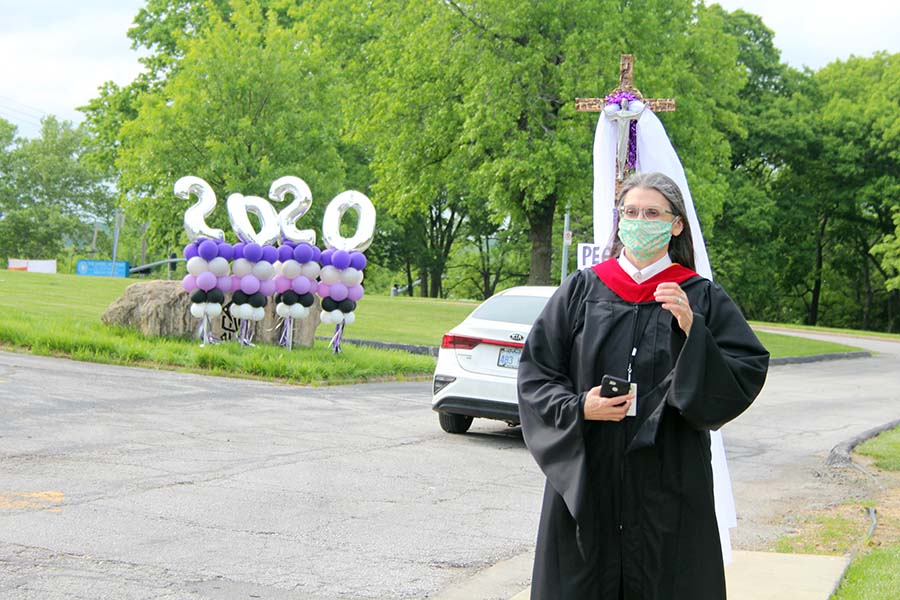 Director of Campus Ministry Stephanie Pino-Dressman waves to the seniors driving through the graduation parade in the parking lot on May 21.