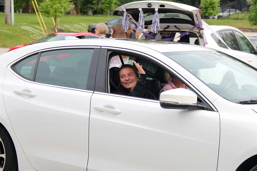 Senior Rose Orrick waves to her teachers during the graduation parade in the parking lot on May 21. 