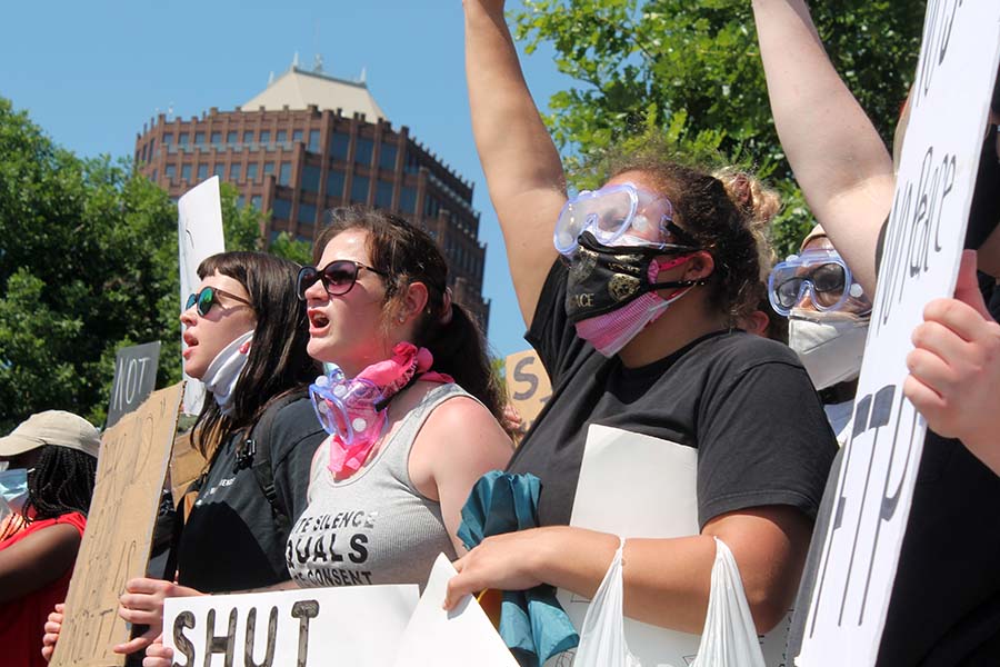 Protesters holding signs chant rallying cries at the Kansas City Police offers surveying the crowd during the Black Lives Matter demonstration at the Country Club Plaza on May 31. 