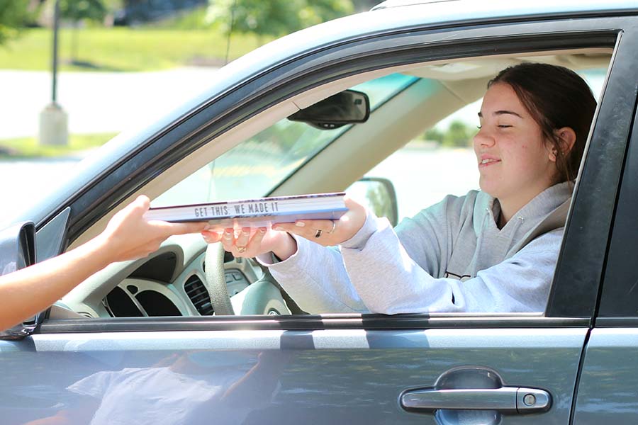 Sophia Angrisano, Class of '20 receives her copy of the yearbook from her car in the parking lot on Aug. 5. The theme of the yearbook is "Get This."