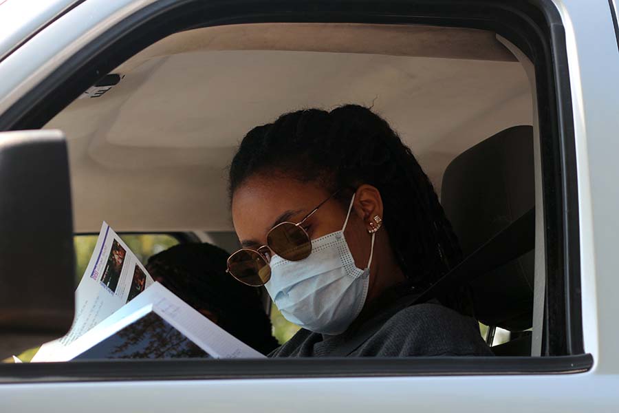 Munachi Okuagu, Class of '20 flips through her yearbook in her car after receiving her copy of the book in the parking lot on Aug. 5. "The yearbook is amazing, everyone who worked on it did an outstanding job," Okuagu said. "My favorite thing about it is the theme 'Get This.' It really suits the times we are living in right now."