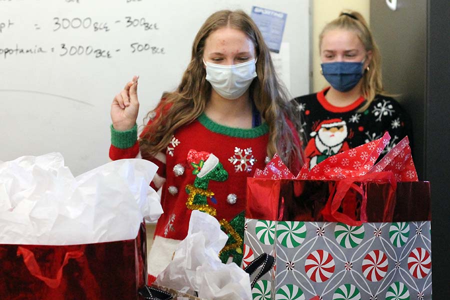 After pulling out the lowest number out of the hat for her maison's white elephant gift exchange, senior Katelyn Brinkman decides which present she wants choose to open first.