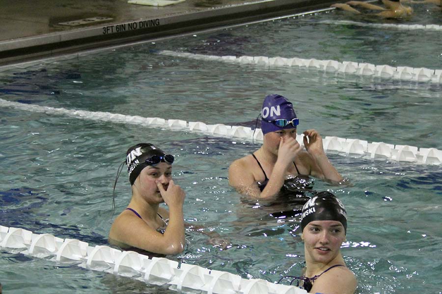 Seniors Emma Grojean, Kate Vankeirsbilck and Elicia Baranowski chat during their warm ups before the swim and dive meet against St. Teresas Academy at the Red Bridge YMCA on Jan. 26. 