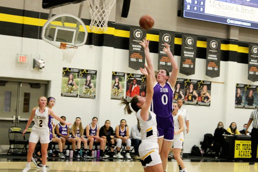 Freshman Grace Renners collides with a St. Teresas player as she goes in for a layup.