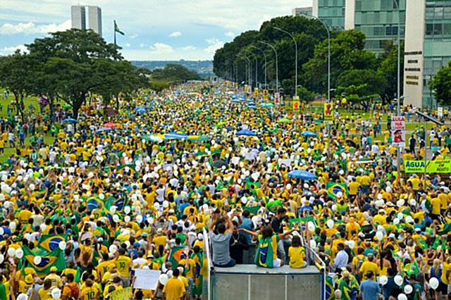 A sea of Brazilian protesters gather together dressed in the country's colors. 