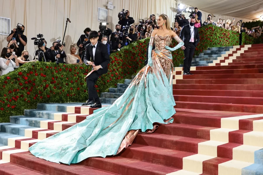 Actress Blake Lively's custom Versace gown, resembling classic New York architecture, cascades down the steps of the Met at the 2022 Met Gala. 