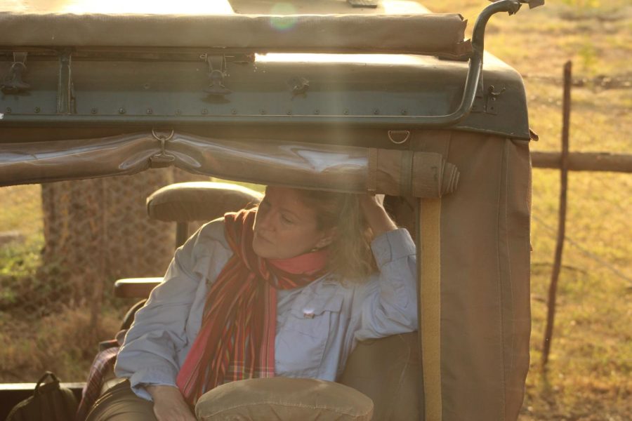 After returning from a morning game drive Mission Director Annie Riggs relaxes in the front seat of a vehicle.