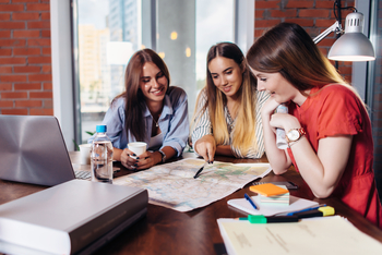 Three women are studying together. While studying in a group like this may look like fun, this article will explain why it’s better to study on your own.