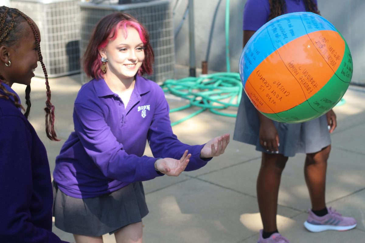 Beach Ball Bonding 
Junior Allie Serville catches a ball as a part of a get-to-know-you game. “While I am atheist, Ive always found religion and religious traditions very beautiful and interesting, which led me to do my own research about different religions purely for fun,” Serville said. “When I heard Sion had a club in which students could learn and celebrate other religions and religious beliefs I saw it as a perfect opportunity to meet like-minded peers.”