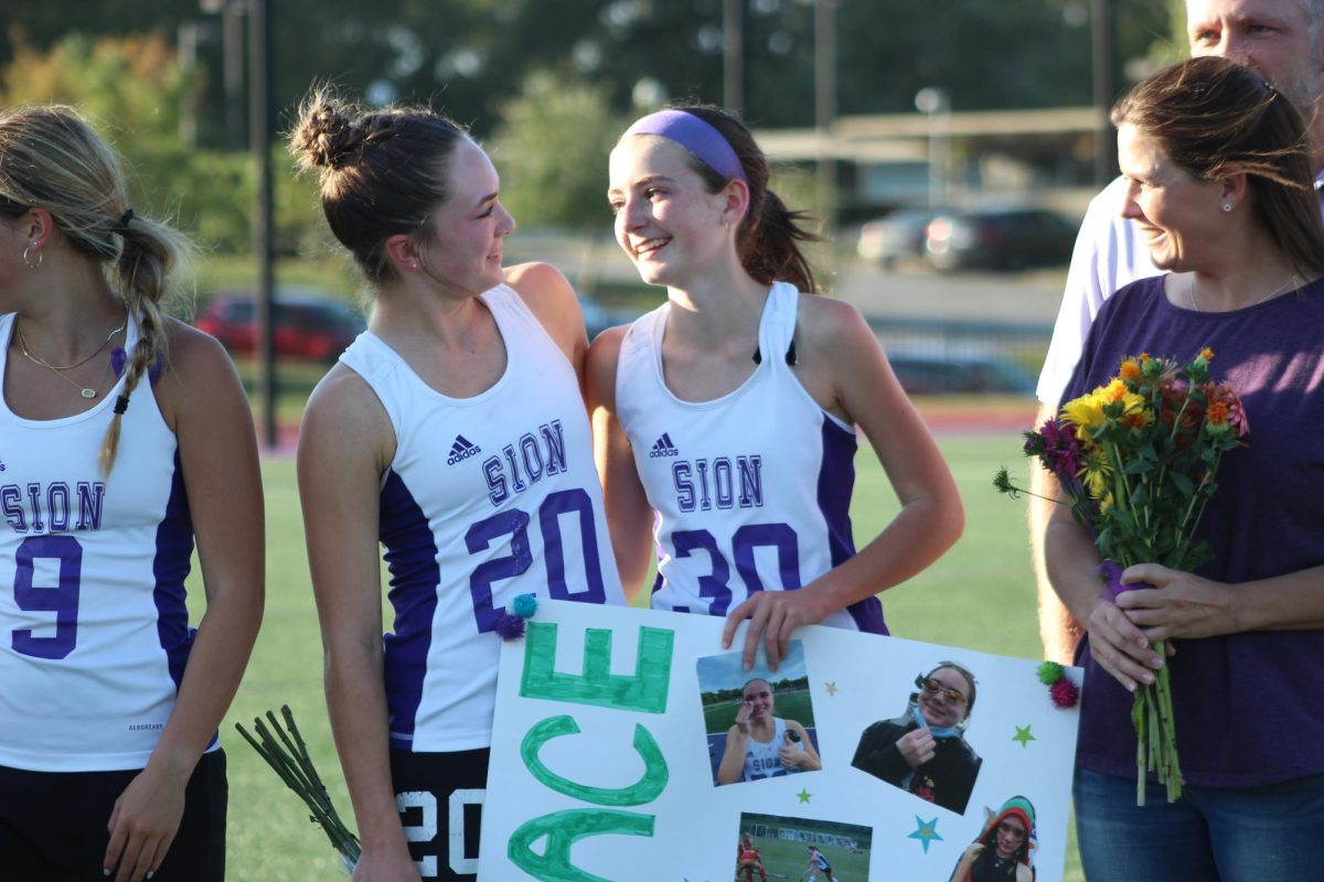 Sister Sister As Senior Grace Kiewiet looks at her little sister, freshman Evelyn Kiewiet holds her big sisters sign.
PHOTO BY: ADDIE DOYLE 