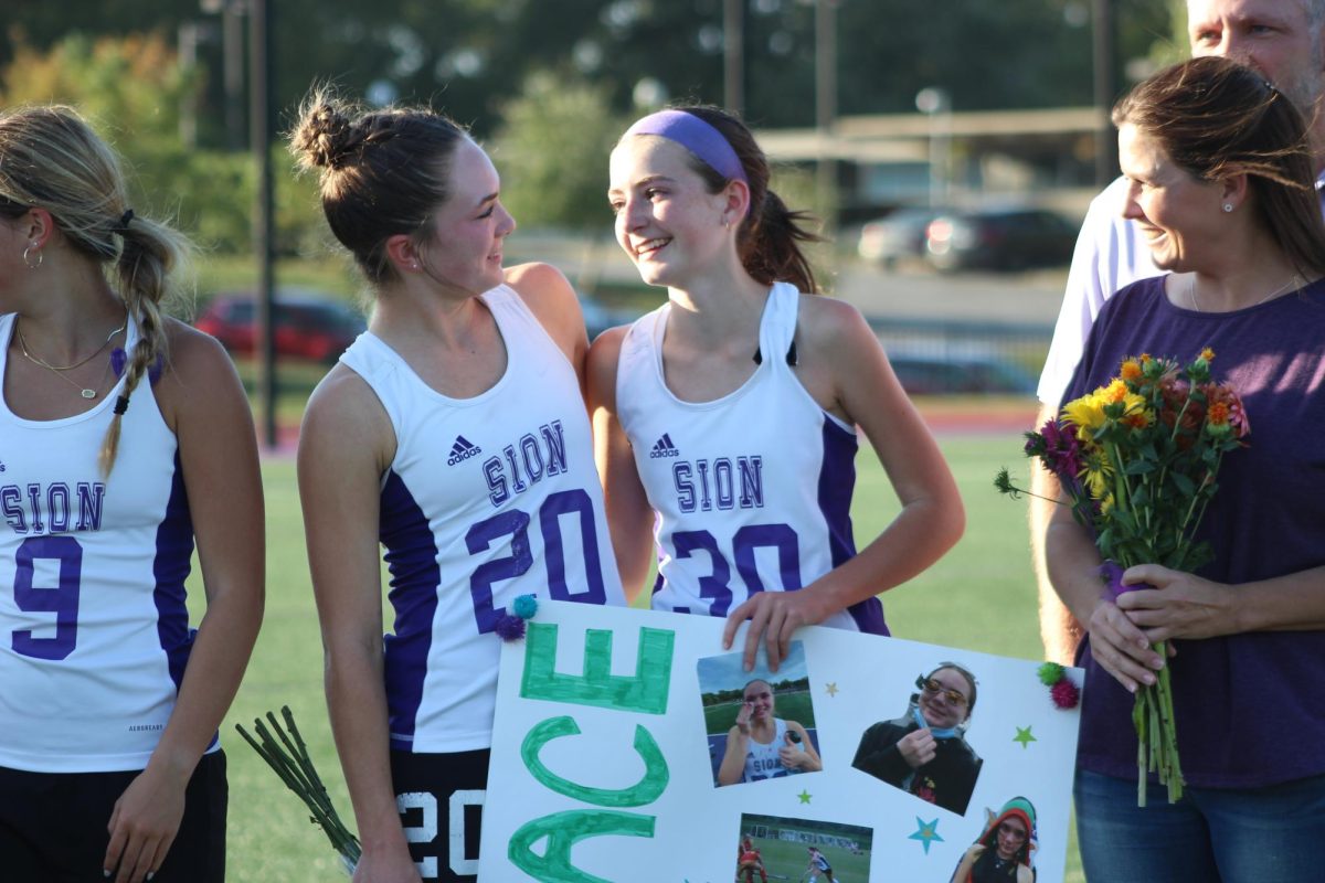 Sister Sister As Senior Grace Kiewiet looks at her little sister, freshman Evelyn Kiewiet holds her big sister's sign.
PHOTO BY: ADDIE DOYLE 