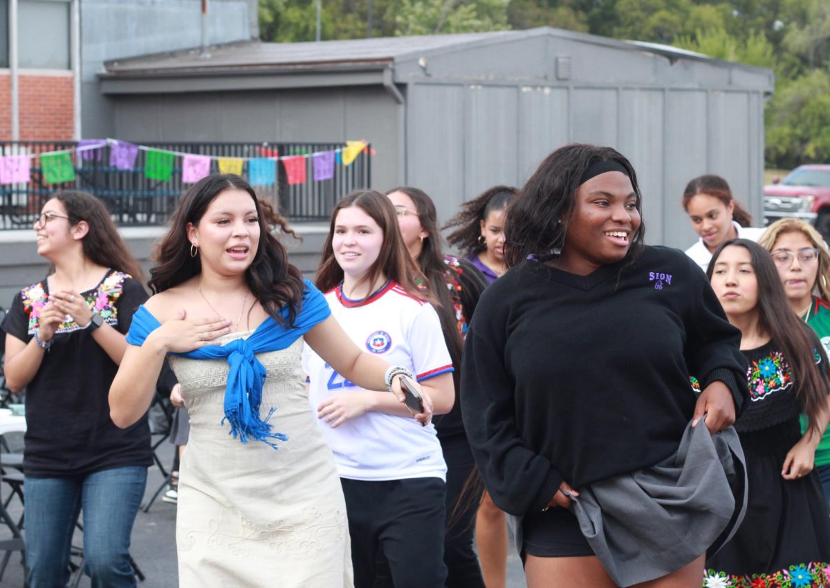 Seniors Genesis Martinez Porras and Imani Cutler smile as they dance with a group. Spanish for Heritage Speakers students curated a playlist for the celebration of songs that celebrate Hispanic Heritage.