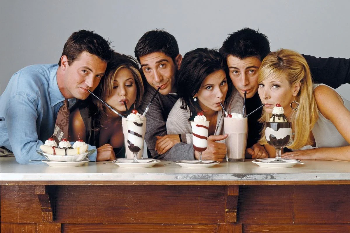 Friends cast drinking milkshakes. 