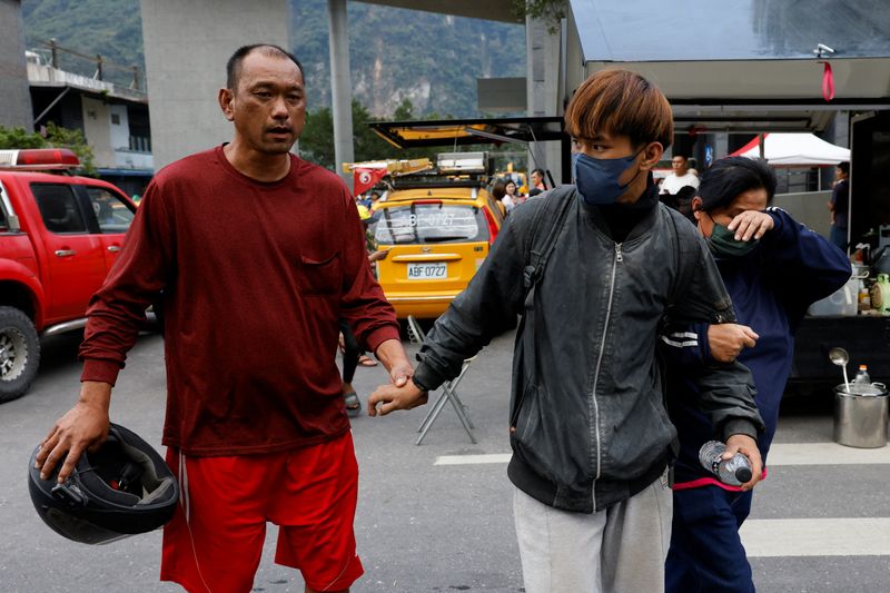 Relatives walk with a man who was rescued from a remote area, following the earthquake, in Hualien, Taiwan, Apr. 4.