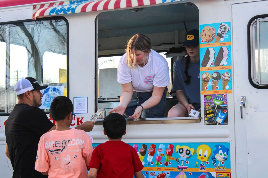 Junior Kate Schneeberger serves ice cream to customers in Meadowbrook park.