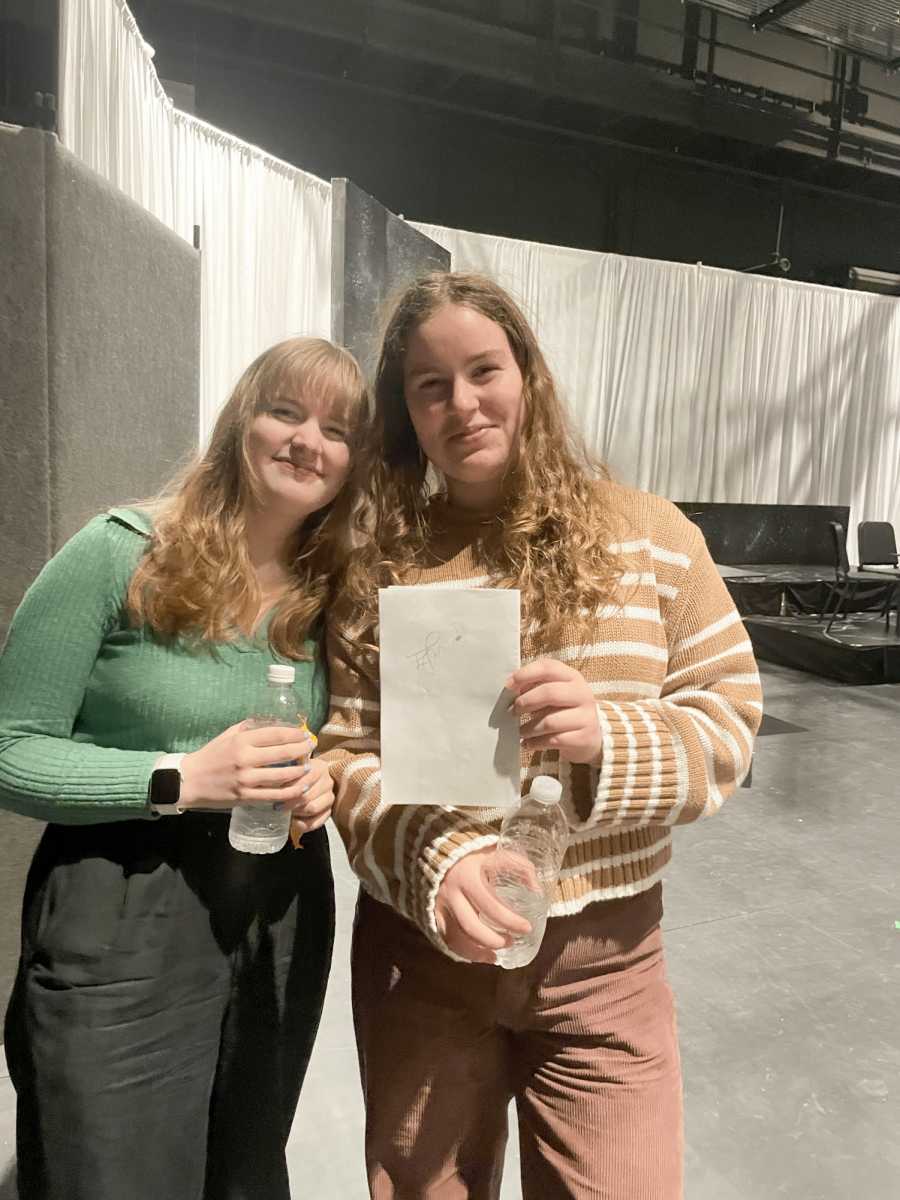 Sophie and Isabel Heidelmann pose in front of the set for Sions 2024 Spring play The Twilight Zone.