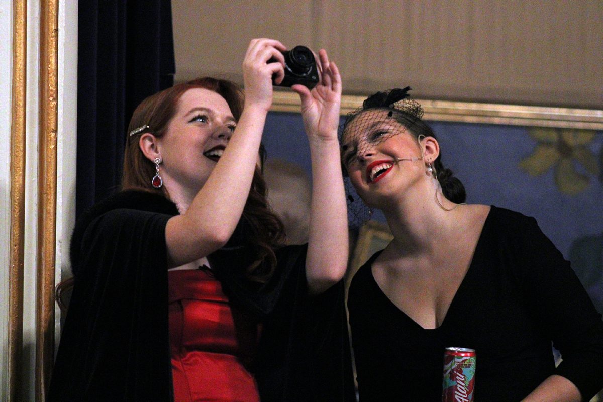 Before the first performance of "CLUE", seniors Adele Milligan and Heidi Nance take pictures of their stage and set. Nance and Milligan felt sentimental emotions looking back on their experience with Sion theater.